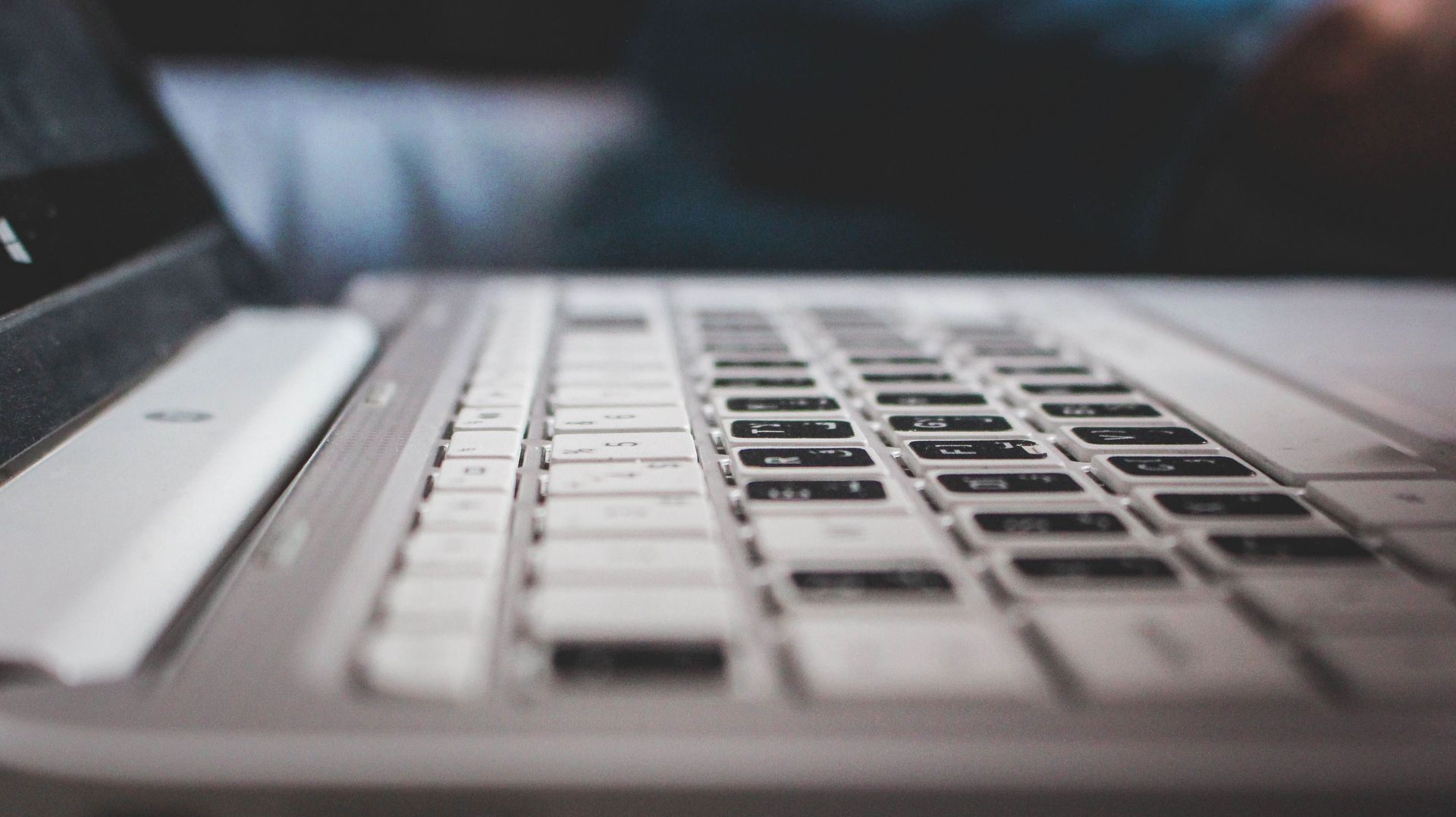 Contemporary powerful netbook keyboard with black and white keys and touchpad placed  on desk